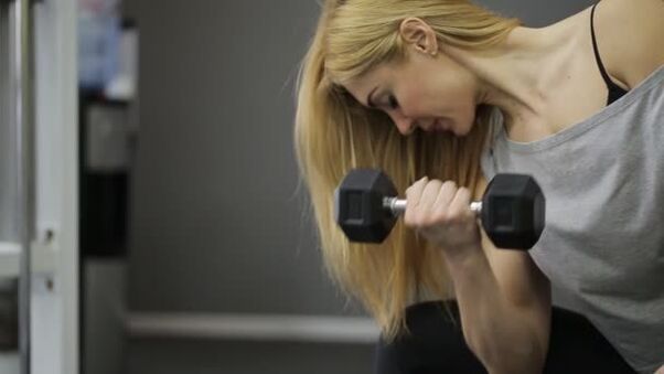La ragazza esegue un esercizio di manubri